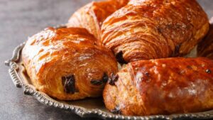Plusieurs pains au chocolat et chocolatines sur un plateau